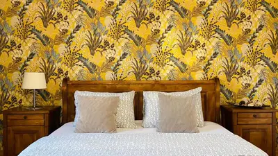 a bed with two pillows in a bedroom with a wallpaper at GARDEN OF EDEN Modern Apartments - APARTELLO,com in Sveti Vlas