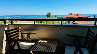 a balcony with two chairs and a table and a view of the ocean at GARDEN OF EDEN Modern Apartments - APARTELLO,com in Sveti Vlas