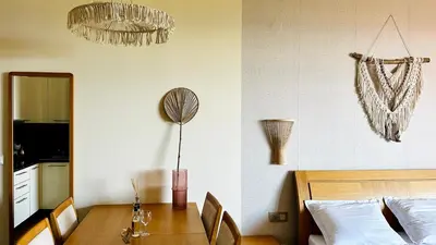a dining room with a table and a bed at GARDEN OF EDEN Modern Apartments - APARTELLO,com in Sveti Vlas
