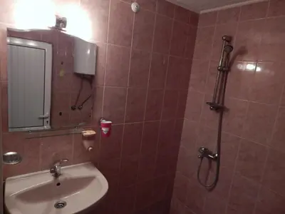 a bathroom with a sink and a shower with a mirror at Dunav Apt.1 in Ravda