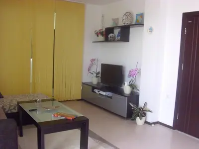 a living room with a tv and a coffee table at Apartament Villa Del Mare in Primorsko