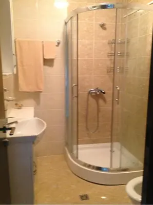 a bathroom with a shower and a toilet and a sink at Apartament Villa Del Mare in Primorsko