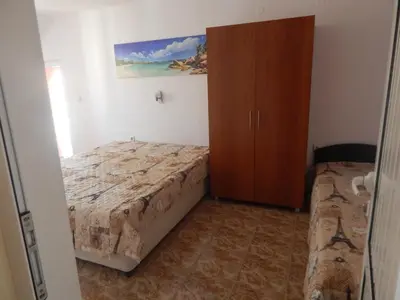a small bedroom with a bed and a cabinet at Dunav Apt.2 in Ravda