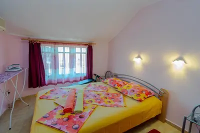 a bedroom with a yellow bed with flowers on it at Fener Guest House in Pomorie