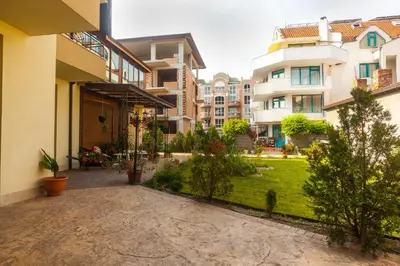 a courtyard of a apartment building with a yard at Ravda Bay Guest House in Ravda