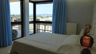 a bedroom with a bed and a view of a balcony at Oasis Beach Studios in Sunny Beach