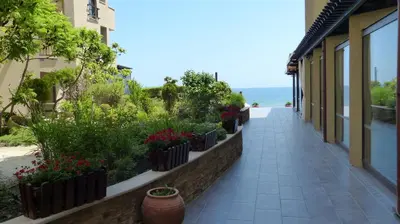 a walkway next to a building with flowers and plants at Oasis Beach Studios in Sunny Beach