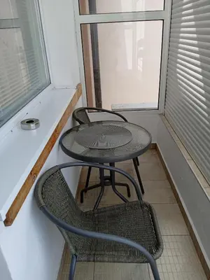 a small table and two chairs in a room with a window at Къща за гости Ганчеви in Sozopol