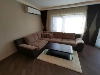 a living room with a brown couch and a glass table at City Center Lux Apartment in Varna City
