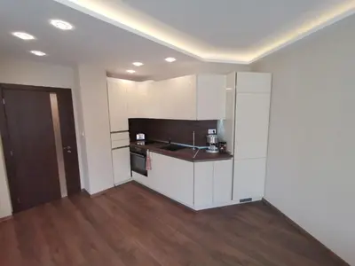 a kitchen with white cabinets and a counter top at City Center Lux Apartment in Varna City