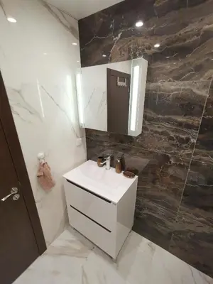 a bathroom with a white sink and a mirror at City Center Lux Apartment in Varna City