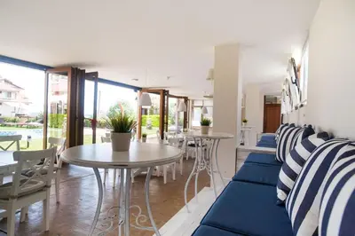 a living room with blue and white chairs and tables at Семеен хотел