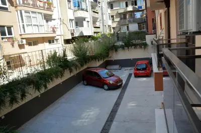two cars parked in a parking lot in front of buildings at Unbeatable Location - New Lux Apartment Varna beach by Flat Mаnager in Varna City