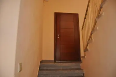 a hallway with a wooden door and stairs at Апартамент ELSOR in Burgas City