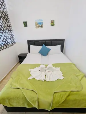 a bedroom with a bed with a green blanket at FREGATA 15 Studio Sveti Vlas in Sveti Vlas
