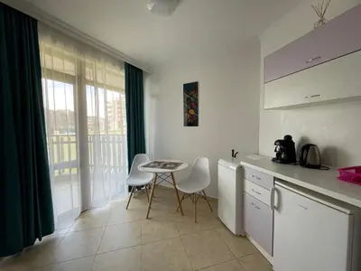 a kitchen with a table and chairs and a window at FREGATA 15 Studio Sveti Vlas in Sveti Vlas