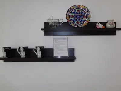 a shelf with vases and a plate on it at Zoya Apartment in Burgas City