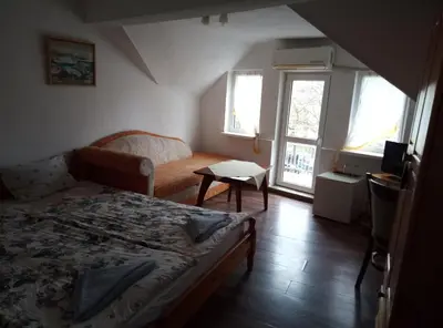 a bedroom with a bed and a table and windows at Casablanca City in Varna City