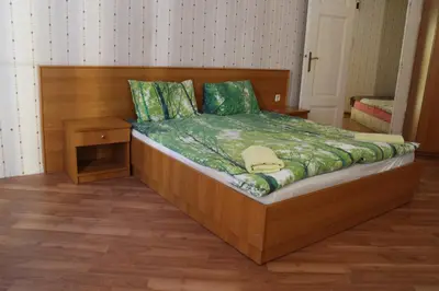 a bedroom with a bed with a wooden headboard at Casablanca City in Varna City