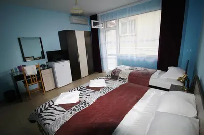 a hotel room with two beds and a window at Zoya Guest House in Ravda