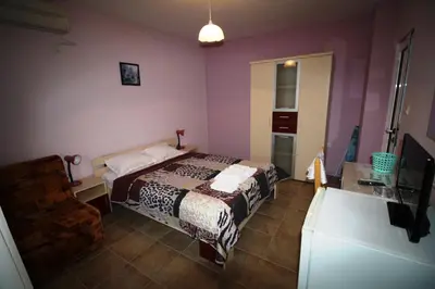 a bedroom with a bed and a television in it at Zoya Guest House in Ravda