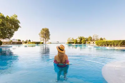 a woman in a hat in the water at a swimming pool at Dreams Sunny Beach Resort and Spa - Premium All Inclusive in Sunny Beach