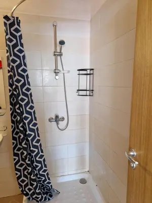 a shower with a black and white shower curtain at Pool View Studio, Pollo Resort, Sunny Beach in Sunny Beach