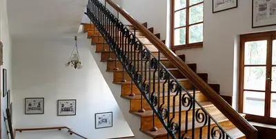 a spiral staircase in a home with white walls at Citadel Guest House in Varna City