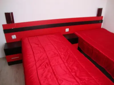 a bedroom with two beds with red sheets at Guest House Perla in Obzor