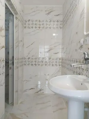 a white bathroom with a sink and a shower at Guest House Perla in Obzor
