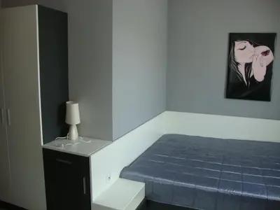 a bedroom with a bed and a painting on the wall at Guest House Perla in Obzor