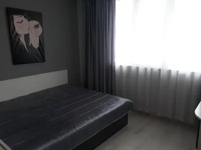 a bedroom with a black bed and a window at Guest House Perla in Obzor