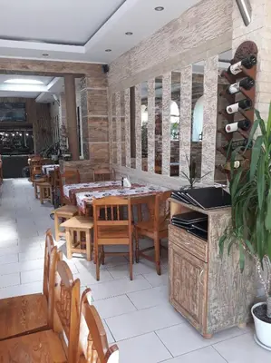 a dining room with wooden tables and chairs at Guest House Perla in Obzor