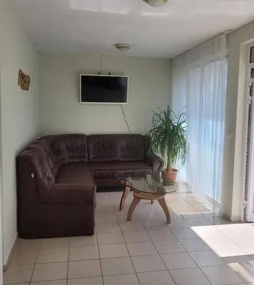 a living room with a brown leather couch and a table at Guesthouse Iceberg in Ravda