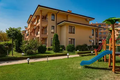 a playground with a slide in front of a building at Menada Sky Dreams Apartments in Sveti Vlas