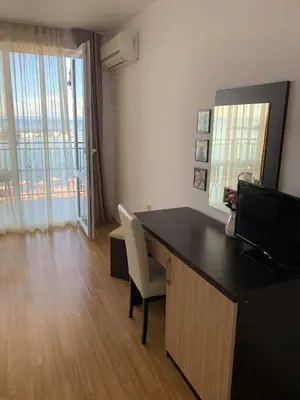 a office with a desk with a chair and a television at Вила Лазурен бряг in Chernomorets