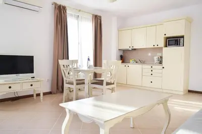 a living room with a table and a kitchen at Oasis Resort Lozenets in Lozenets