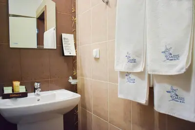 a bathroom with towels and a sink and a toilet at Oasis Resort Lozenets in Lozenets