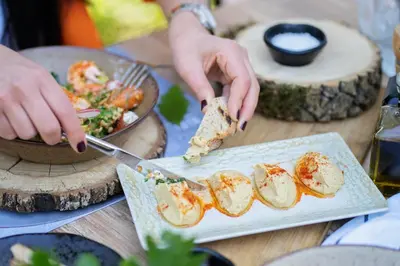 a person eating a piece of food on a plate at Utopia Forest in Burgas City