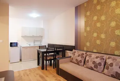 a living room with a couch and a table and a kitchen at Cabana Beach Club Complex in Nesebar