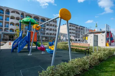 a playground with a slide and a swing set at Belvedere Hotel - All inclusive in Primorsko