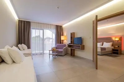 a hotel room with a bed and a living room at Belvedere Hotel - All inclusive in Primorsko