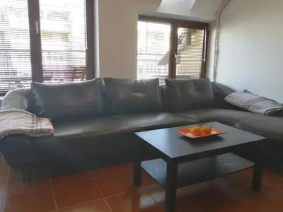 a black leather couch in a living room with a table at INFINITY Blue 2 in Burgas City