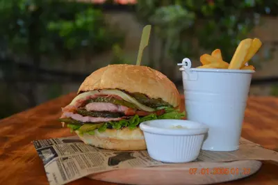 a sandwich and french fries and a cup of sauce at Salena Beach Hotel in Primorsko
