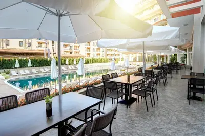 a restaurant with tables and umbrellas and a pool at Maria Palace Hotel - All Inclusive in Sunny Beach