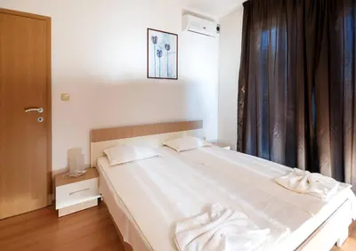 a bedroom with a large white bed and a window at Seaside Garden Apartment with 2 BR for up to 5 pax in Sunny Beach