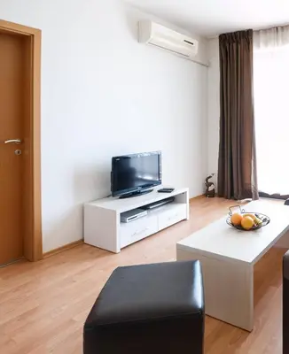 a living room with a tv on a white cabinet at Seaside Garden Apartment with 2 BR for up to 5 pax in Sunny Beach