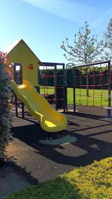 a yellow slide on a playground in a park at Apartments in complex ATIA RESORT in Chernomorets