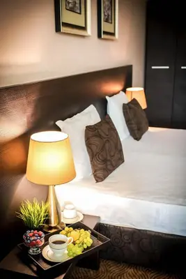 a hotel room with a bed and a table with a lamp at Central Plaza in Pomorie