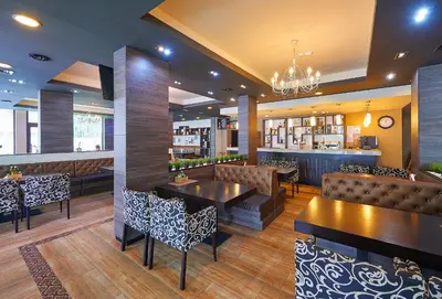 a restaurant with tables and chairs and a bar at Central Plaza in Pomorie